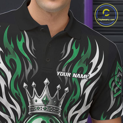 A close-up of a black short-sleeve polo shirt worn by a model, featuring a green and white flame design, a silver crown graphic, and the text 'YOUR NAME' on the chest.