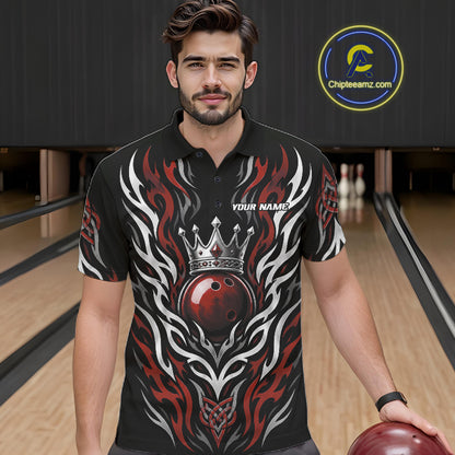A man wearing a black short-sleeve bowling polo shirt with a red and white flame design and a crown graphic, standing in a bowling alley.