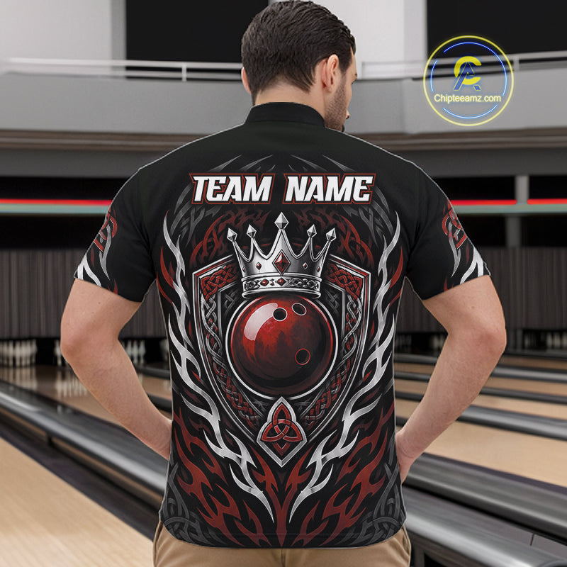 A man viewed from behind wearing a black bowling-themed quarter zip shirt with a large red and silver crown, ball, and flame graphic on the back, standing in a bowling alley.