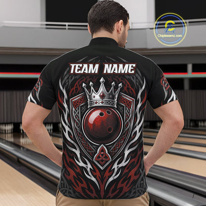A man viewed from behind wearing a black bowling-themed quarter zip shirt with a large red and silver crown, ball, and flame graphic on the back, standing in a bowling alley.