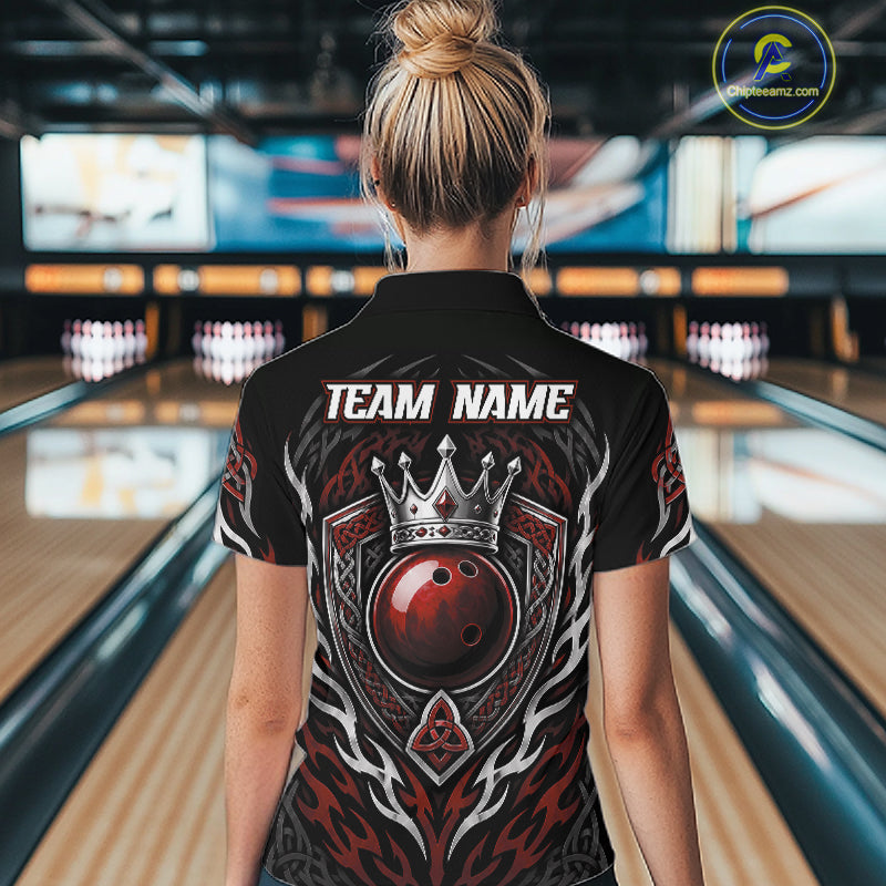 A woman viewed from behind wearing a black bowling quarter zip shirt with a large red, black crowned red bowling ball, and tribal-style patterns, with 'TEAM NAME' printed in white. 