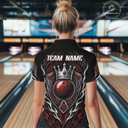 A woman viewed from behind wearing a black bowling quarter zip shirt with a large red, black crowned red bowling ball, and tribal-style patterns, with 'TEAM NAME' printed in white. 