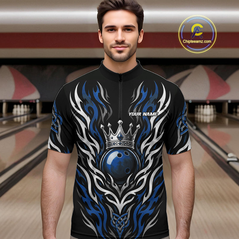 A man wearing a black short-sleeve quarter zip bowling jersey with a blue and silver tribal flame design, a crowned bowling ball graphic. 