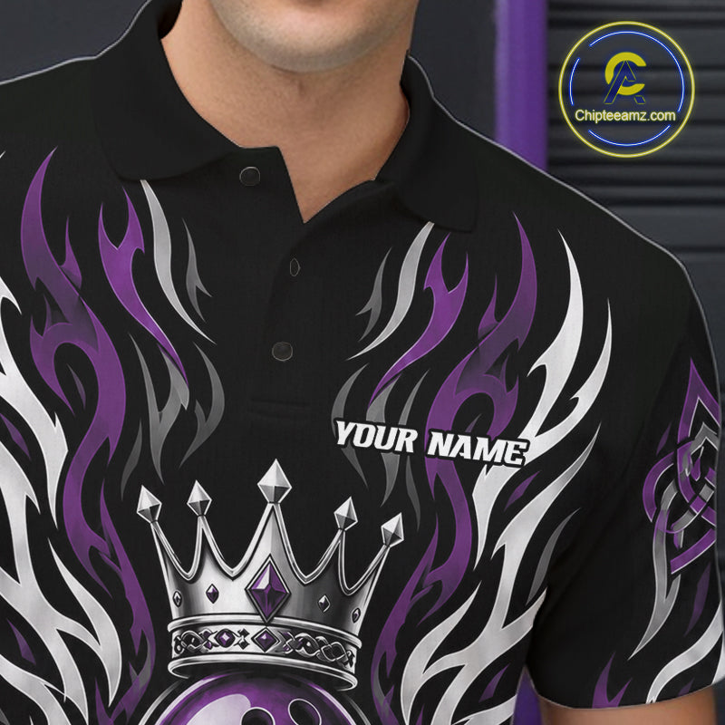 A close-up of a black short-sleeve polo shirt worn by a model, featuring a graphic design with purple and white flames, a silver crown, and the text 'YOUR NAME'