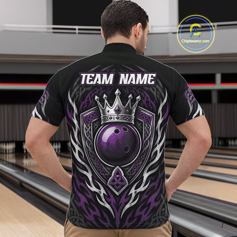 A man viewed from behind wearing a black bowling-themed short-sleeve shirt with a large purple and silver crowned bowling ball graphic on the back, standing in a bowling alley. 