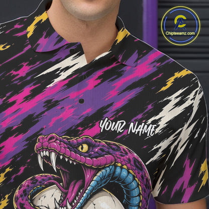 A close-up of a person wearing a short-sleeve polo shirt with a bold graphic print. The shirt features a black base with vibrant magenta, purple, yellow, and white abstract brushstroke patterns, plus a large illustrated snake 
