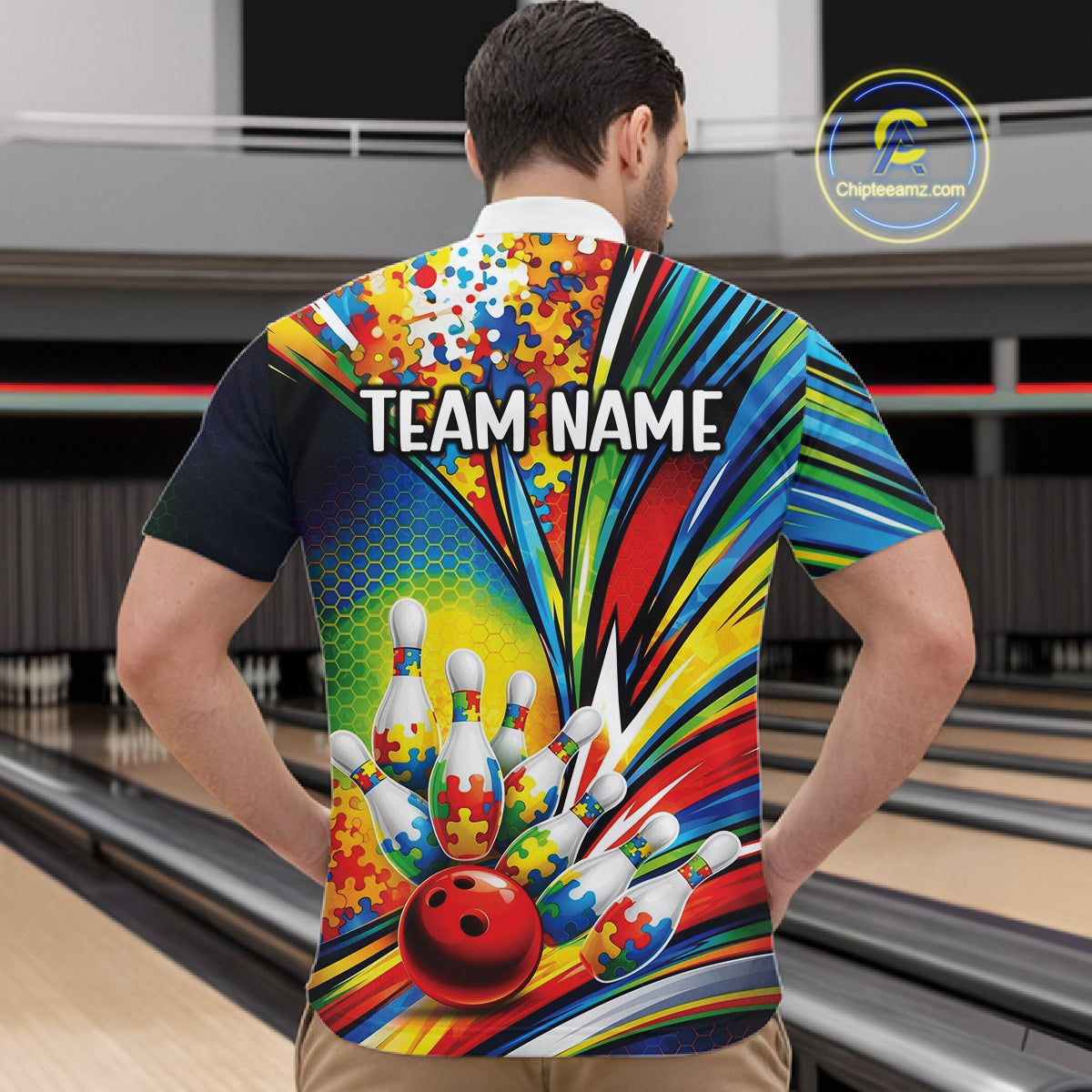 Male Model At Bowling Alley Front View Wearing Bowling Quarter-Zip Featuring Autism Puzzle Motif And Dynamic Bowling Strike Artwork In Bright Colors