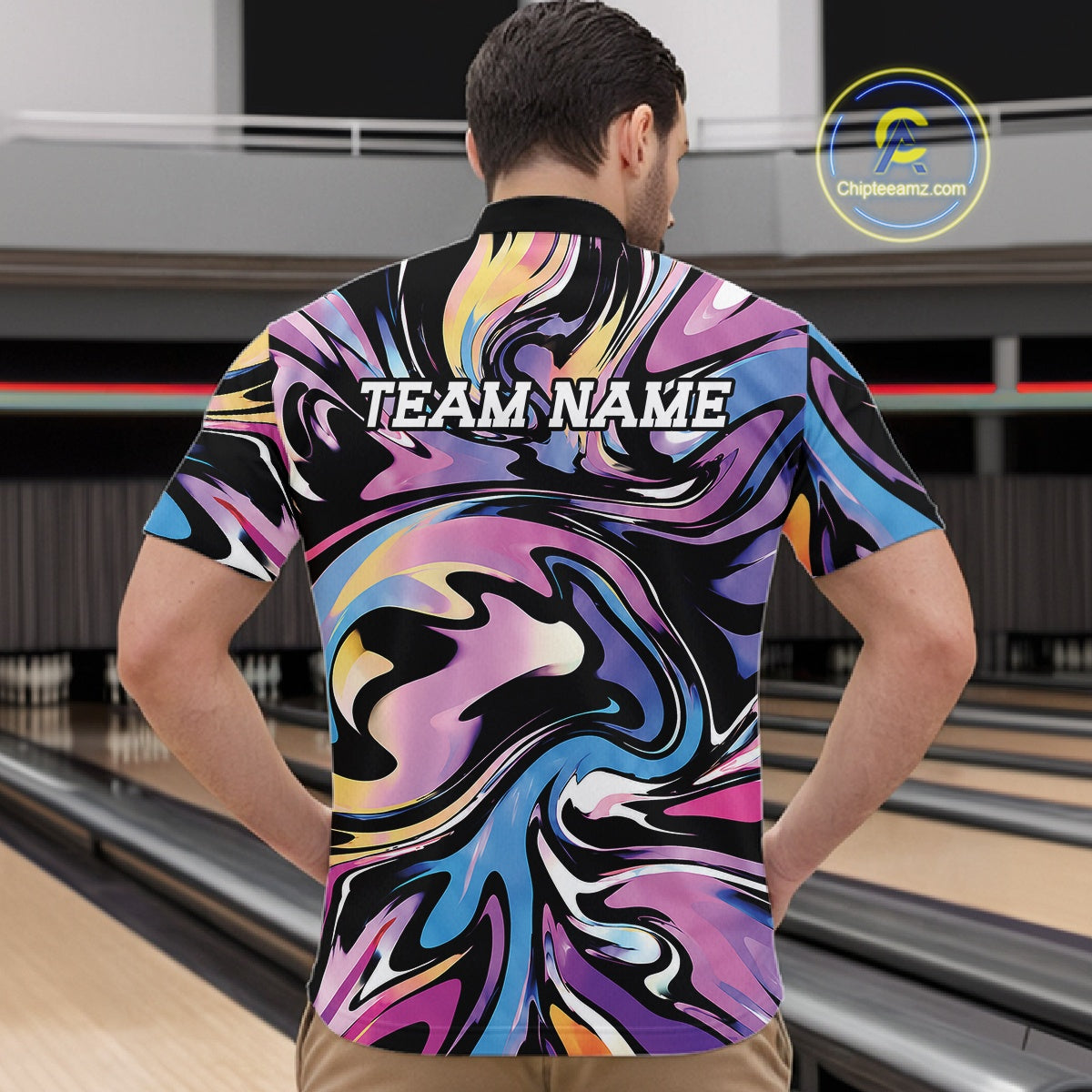Man wearing a colorful bowling shirt with 'TEAM NAME' text in a bowling alley.