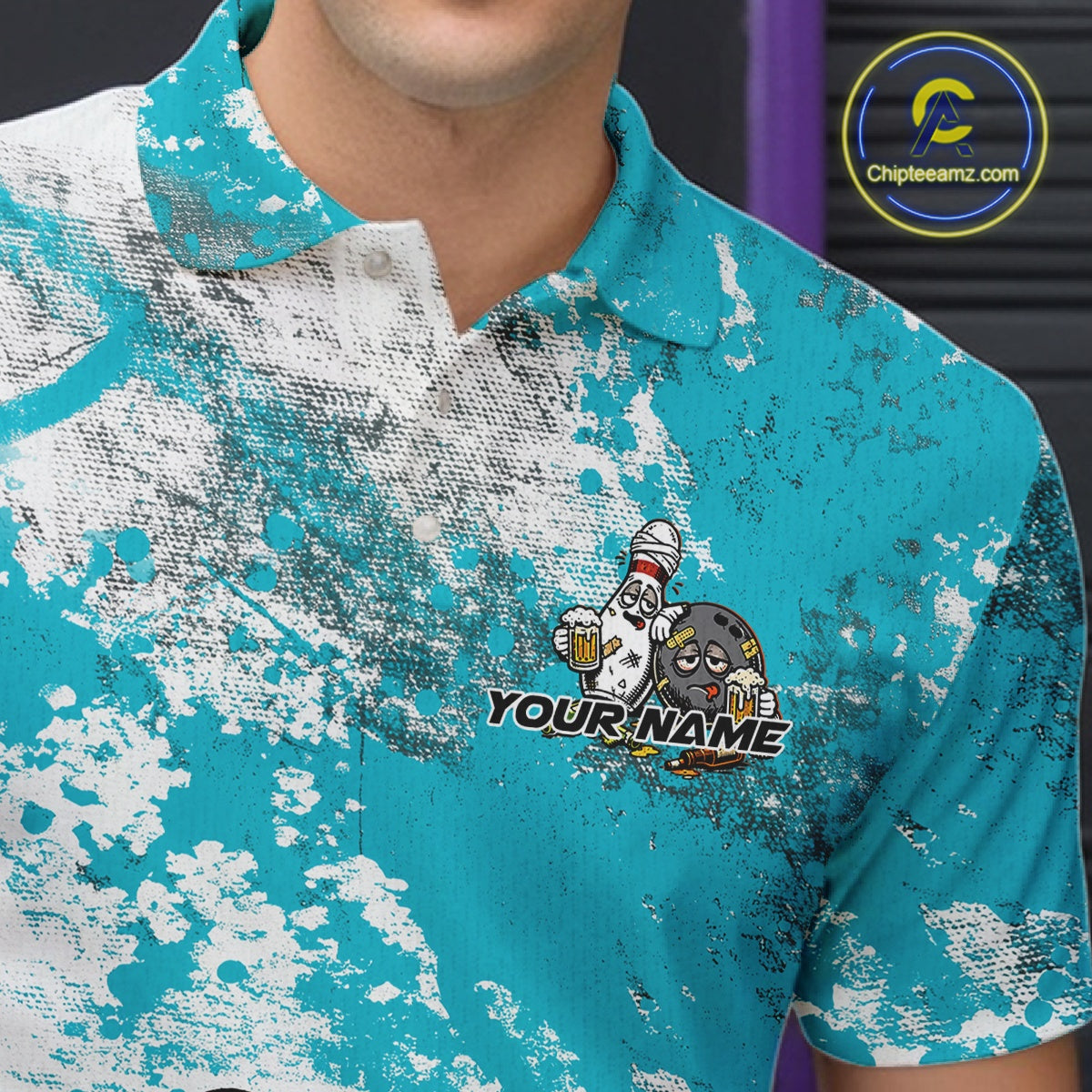 Close-up view of the left chest of a turquoise blue and white grunge splatter polo shirt showing cartoon bowling pins and beer bottle detail artwork.