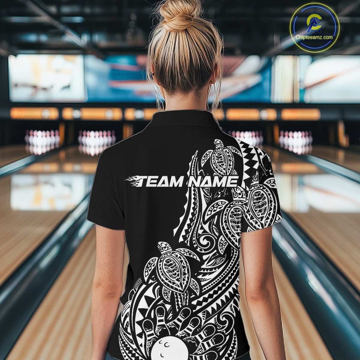 Back view of a female model in a black and white bowling quarter-zip shirt featuring Polynesian-inspired bowling artwork and turtle motifs.