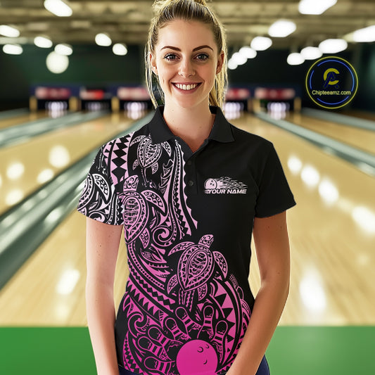 Female model wearing a black and pink bowling polo shirt at the lane with Polynesian-style bowling artwork and tribal details.