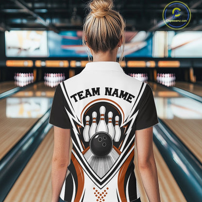 At a bowling lane, a back-view female model wears a white, black, and orange bowling quarter-zip shirt featuring bowling ball knocking down pins artwork.