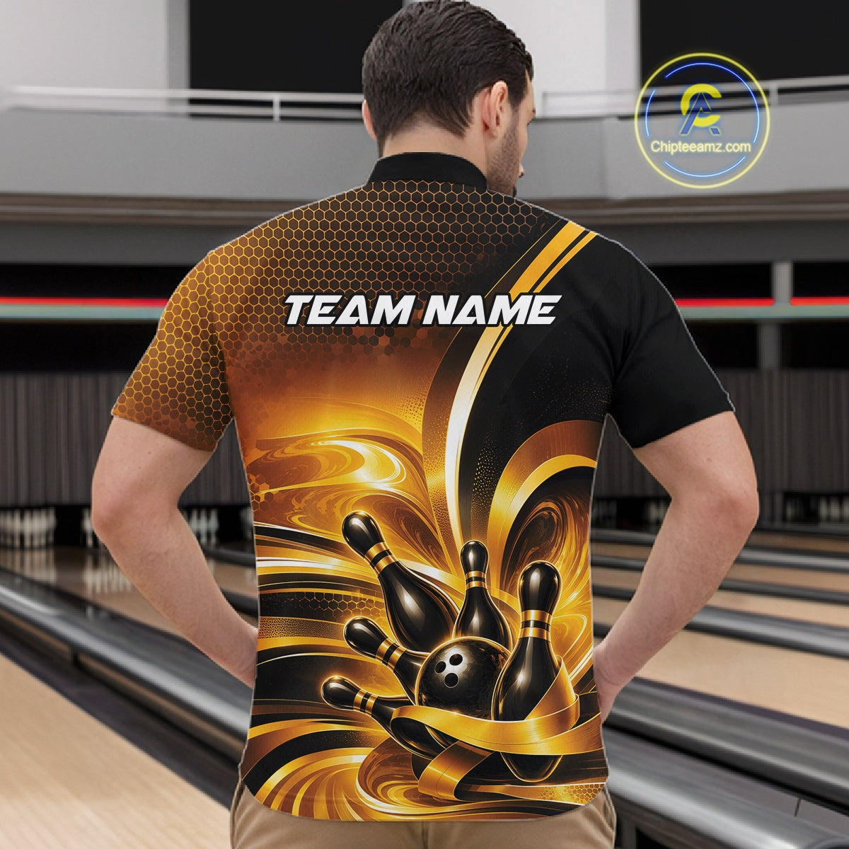Front view of a male model at a bowling lane wearing a bowling quarter-zip shirt with glossy gold and black bowling ball and pins artwork.