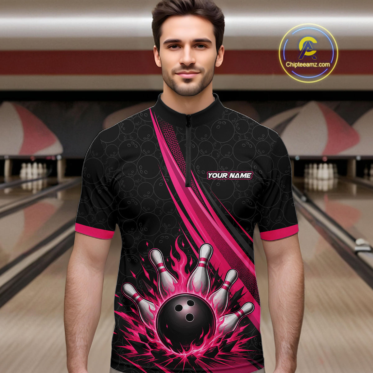 A man wearing a black and pink bowling-themed short-sleeve quarter-zip shirt with a flame and bowling pin graphic on the front, standing in a bowling alley. 