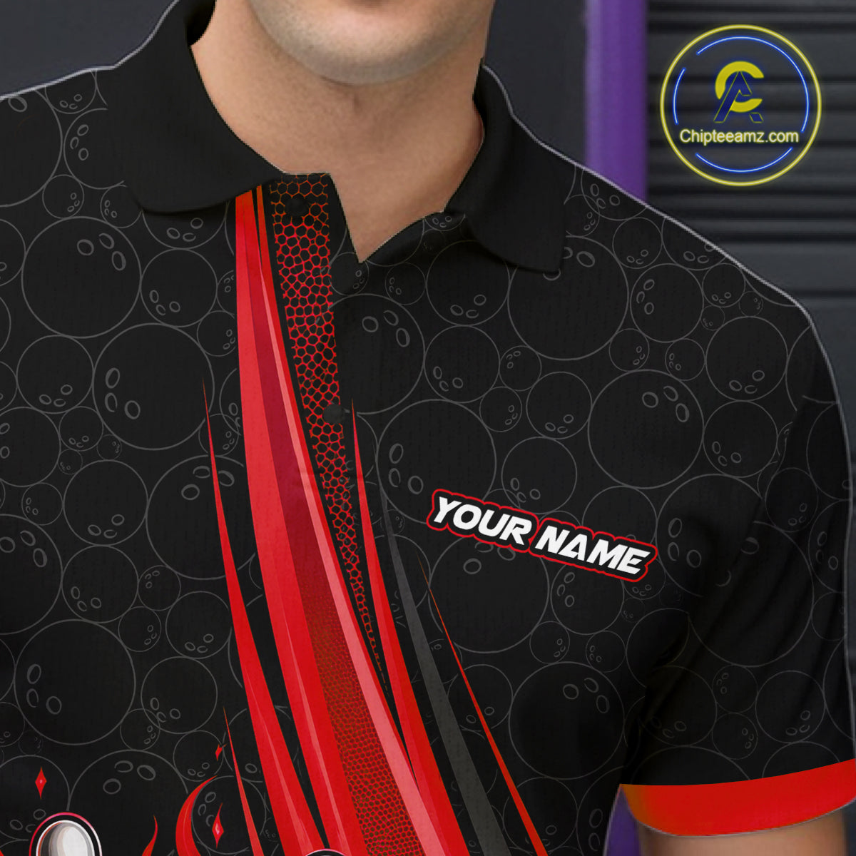 A close-up of a man wearing a black short-sleeve polo shirt with red and gray bowling-themed graphics, including bowling pins, balls, and a diagonal red stripe.
