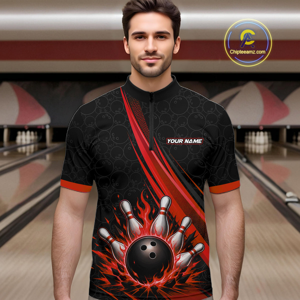 A man wearing a black short-sleeve bowling-themed quarter-zip shirt with red and orange flame graphics, bowling pins, and a bowling ball on the front. The background shows blurred bowling alley lanes.