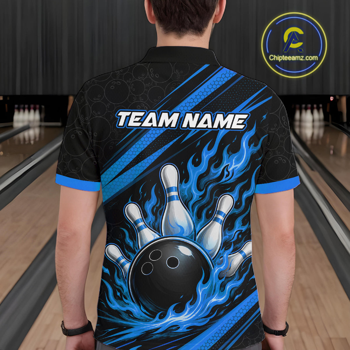 A person viewed from behind wearing a black bowling-themed short-sleeve polo shirt with blue flame graphics, bowling pins, and a black bowling ball on the back, with the text 'TEAM NAME' across the upper back.