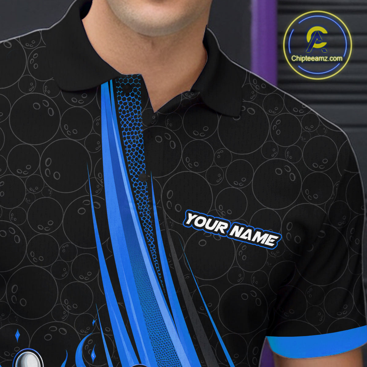 A close-up of a man wearing a black short-sleeve polo shirt with blue and gray bowling-themed graphics, including bowling pins, balls, and a diagonal blue stripe. The shirt has a customizable text