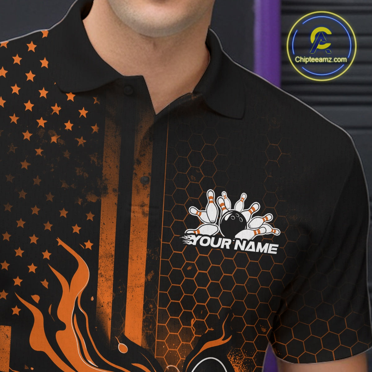 Close-up of a black and orange bowling polo shirt left chest showcasing patriotic flames and bowling strike graphics.
