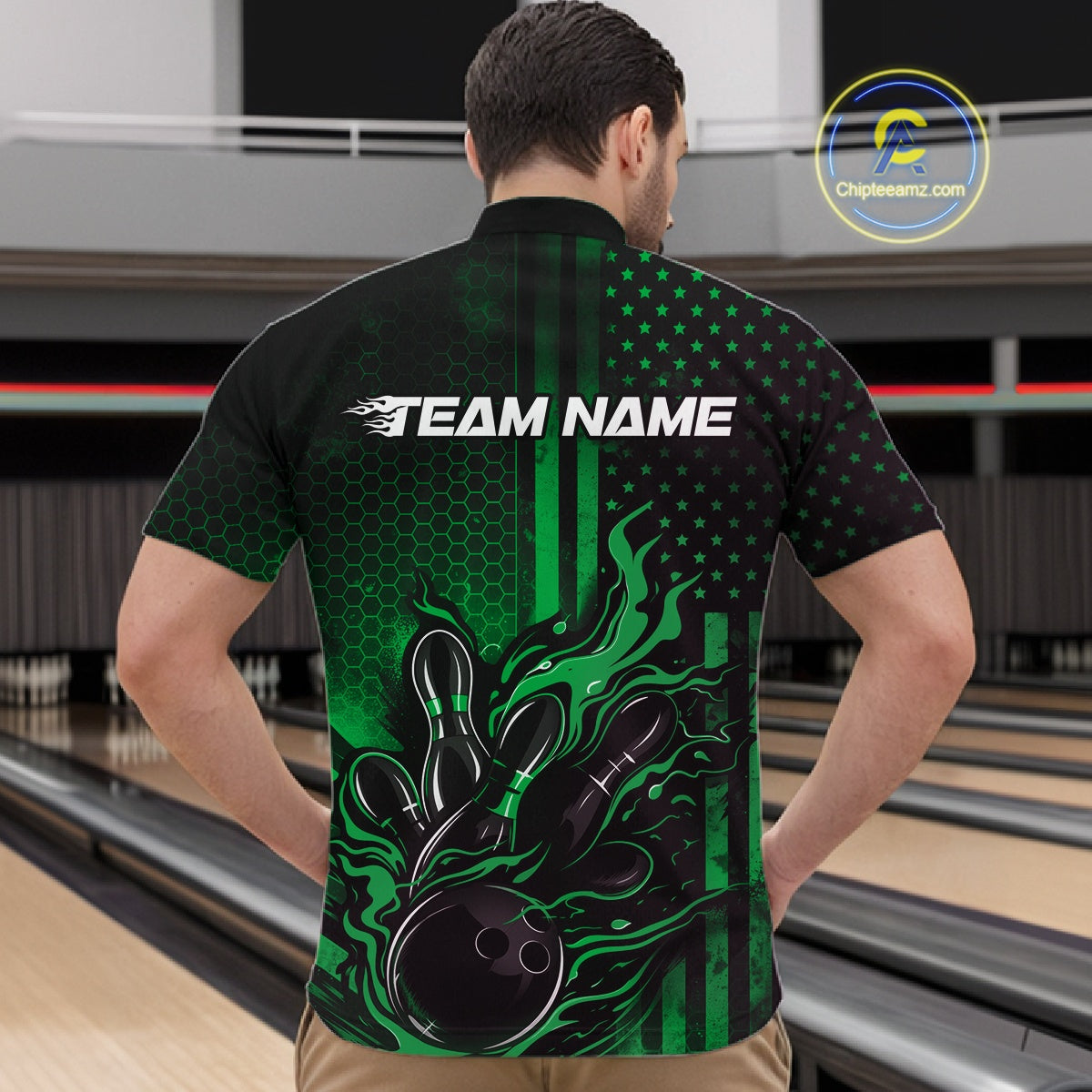 Front view of a male model in a bowling center wearing a black and green quarter-zip shirt featuring a bowling ball and pin motif with flame details.