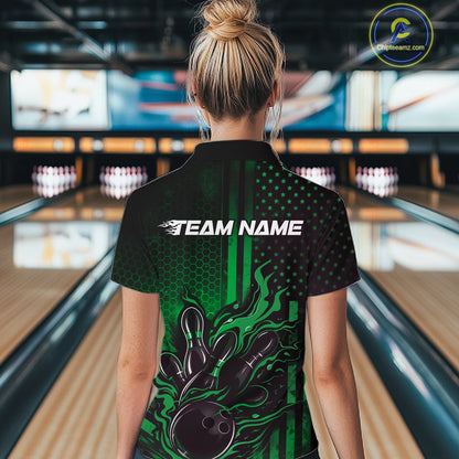Back view of a female model in a bowling venue wearing a black and green quarter-zip shirt featuring a flaming bowling ball and pin motif.