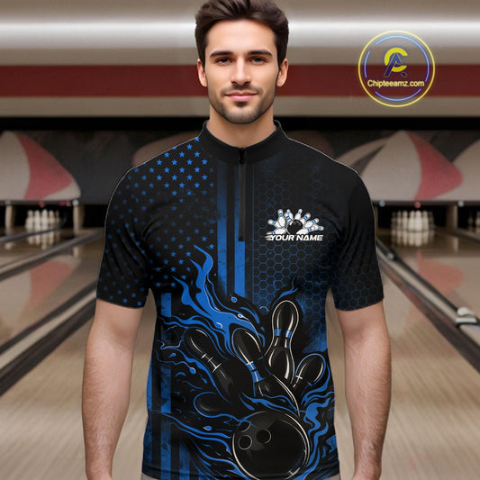 Male model at a bowling lane wearing a black and blue bowling quarter-zip shirt with fiery bowling strike graphics and patriotic details.