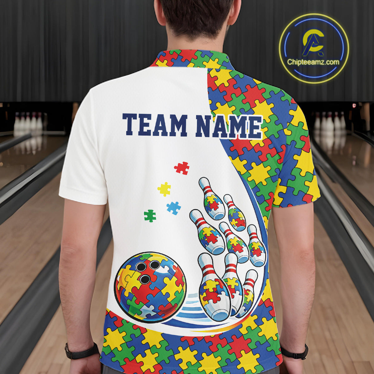 Male model in a bowling lane wearing a white polo shirt, back view featuring colorful autism-themed bowling strikes with puzzle-inspired graphics
