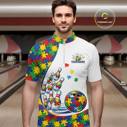 In A Bowling Lane, Front View Male Model Wearing White Quarter-Zip Shirt With Colorful Autism Bowling Strike Illustration And Puzzle Motif Graphics