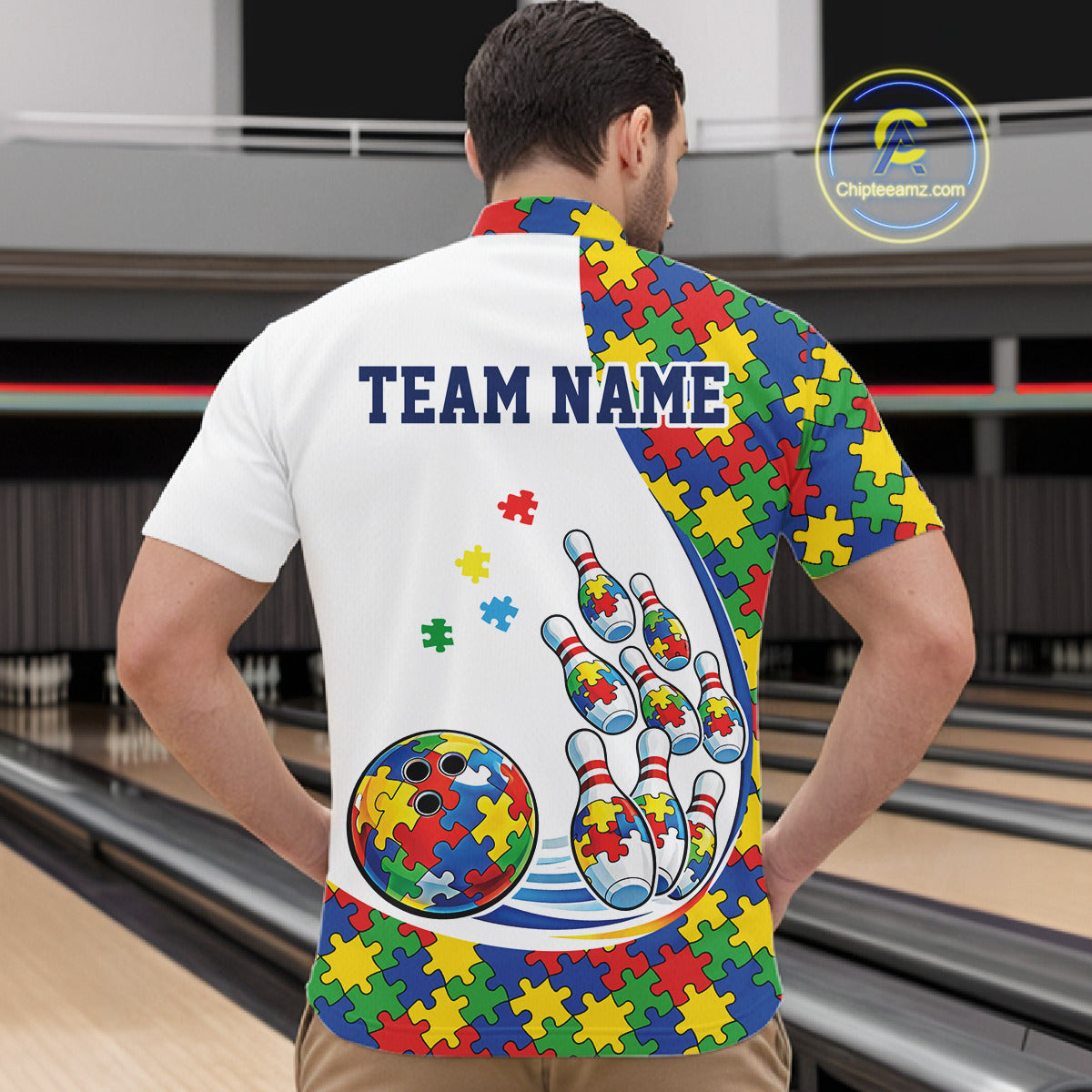 At Bowling Venue, Front View Of Male Model In White Quarter-Zip Shirt, Autism-Themed Bowling Strike Artwork With Vibrant Puzzle Pattern Design