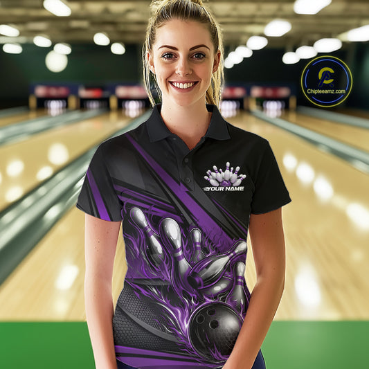 Female model in a bowling lane, front view wearing black polo shirt with purple flame bowling ball hitting pins and geometric stripe graphics
