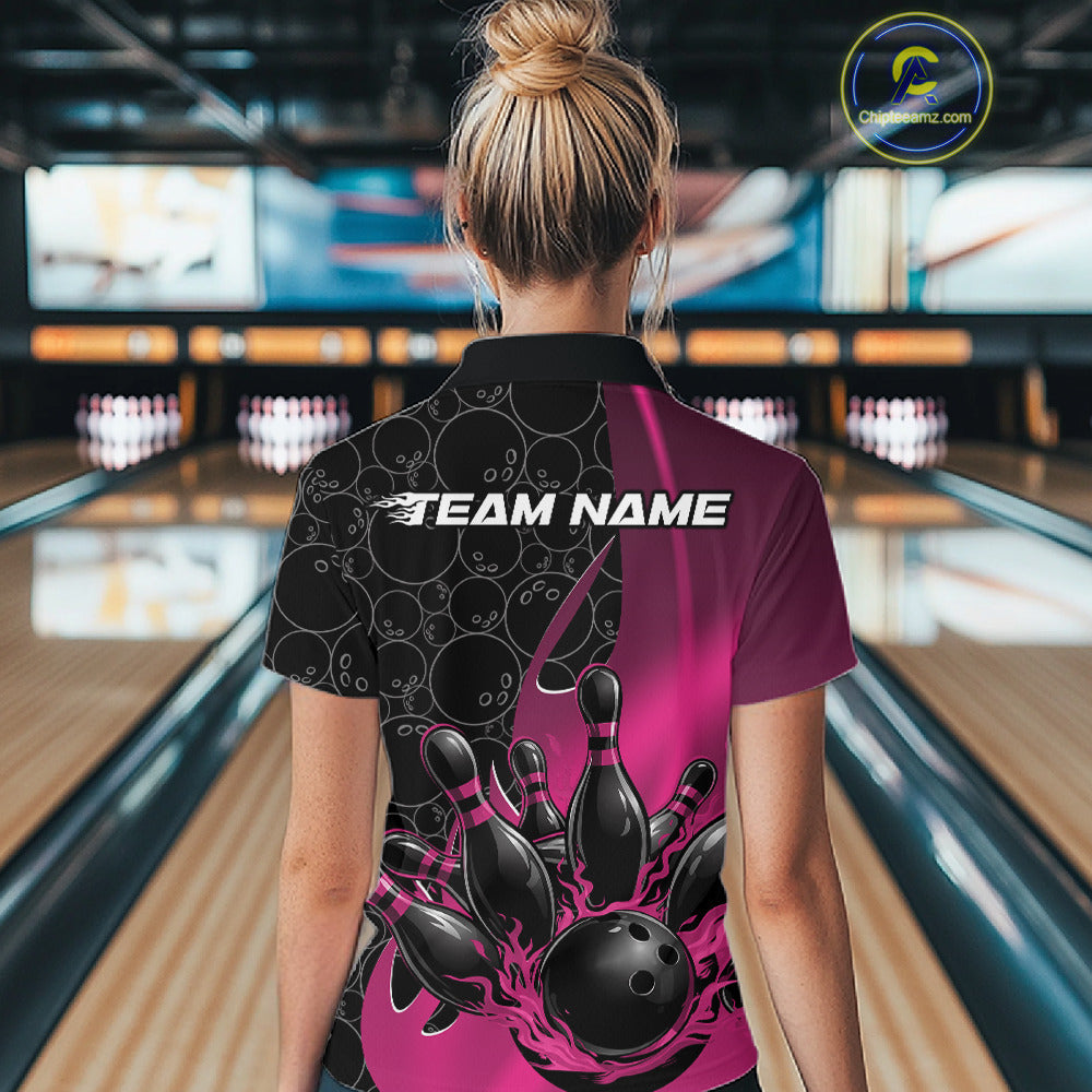 Back view of a female model in a bowling lane wearing a black and pink polo shirt featuring gradient bowling ball pattern with flaming black bowling ball striking pins dynamic design.