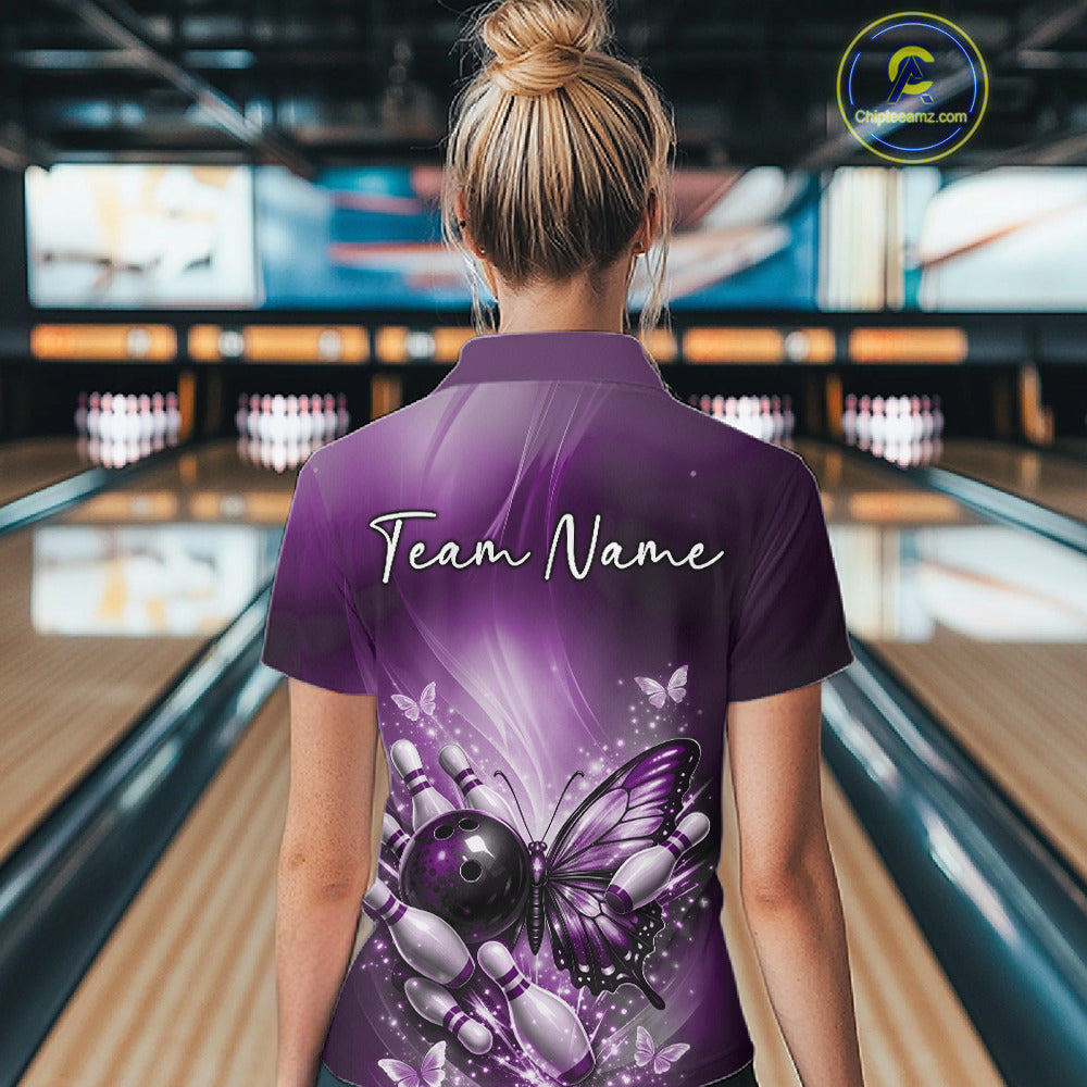 Back view of a female model in a bowling alley wearing a purple polo shirt showcasing a butterfly beside a bowling ball and bowling pins.