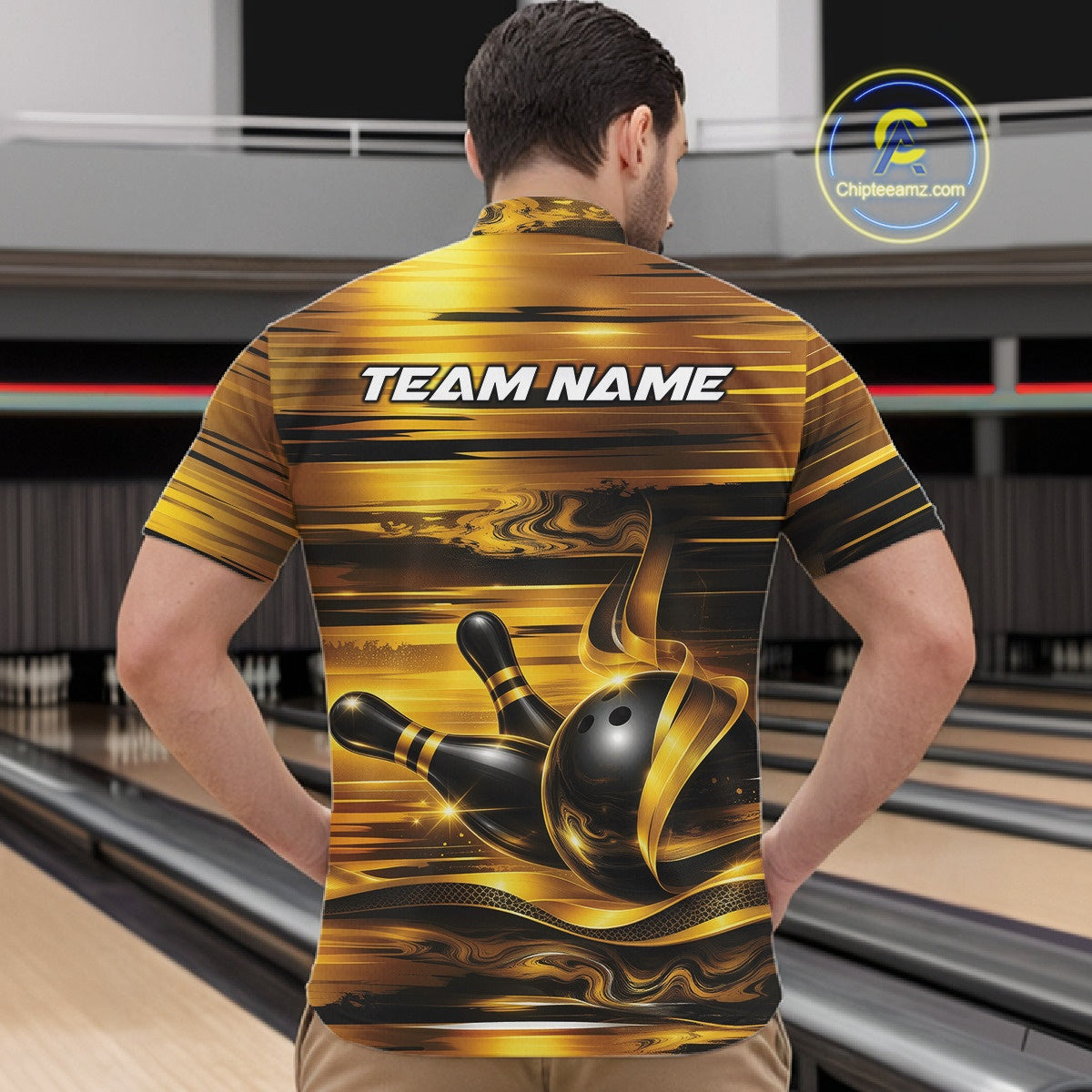 Male model at the bowling lane wearing a bowling quarter-zip shirt, front view, featuring glossy gold and black bowling ball and pins artwork.