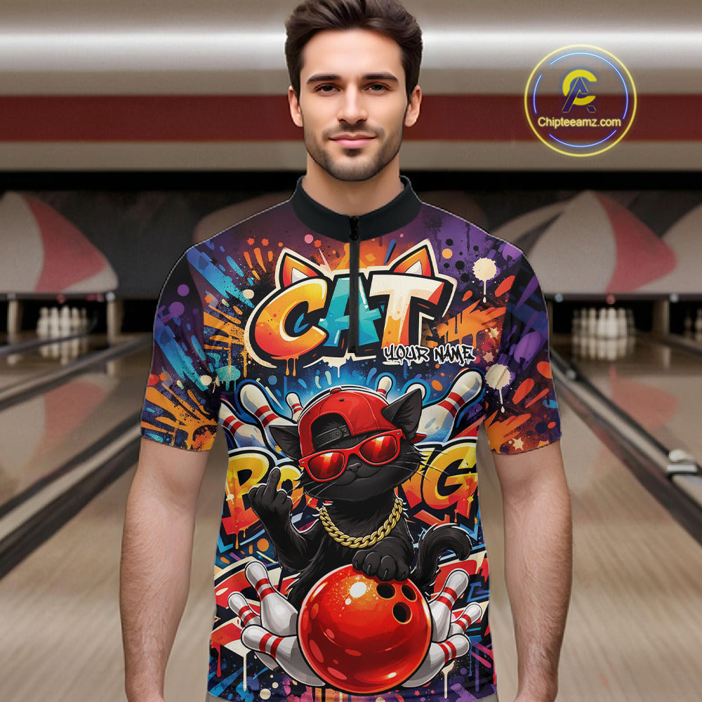 Male model at a bowling lane wearing a colorful quarter-zip bowling shirt with graffiti-style black cat artwork, sunglasses, cap, and bowling ball graphics.