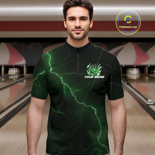 Male model at the bowling lane wearing a black and green quarter-zip with dragon claw graphics and flaming bowling ball details.