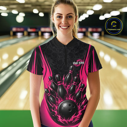 A woman stands in a bowling alley wearing a custom bowling jersey with a black and hot pink flame design featuring bowling pins and a ball graphic. 