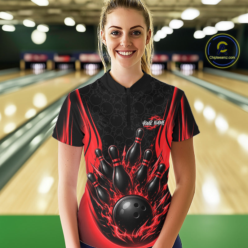 A woman stands in a bowling alley wearing a custom-designed short sleeve bowling quarter zip jersey. The jersey features a black and red flame pattern with a graphic of bowling pins and a flame bowling ball on the front
