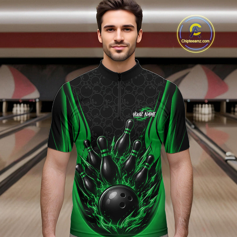 A man wearing a short-sleeve bowling quarter zip shirt with a black and green flame bowling pin graphic, standing in a bowling alley. The jersey features a black and green flame bowling pin graphic, with the words 'Your Name' printed on the chest.