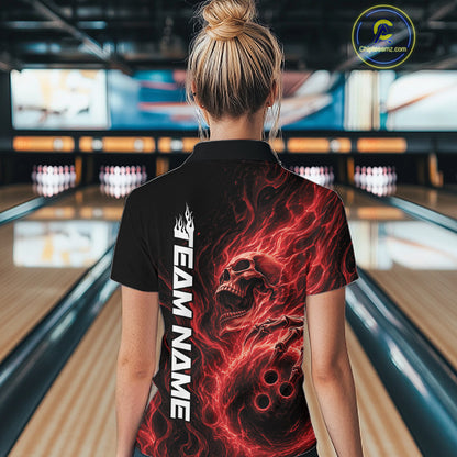 Back view of a female bowler in a bowling alley wearing a black bowling quarter-zip shirt with a red flaming skull holding a bowling ball amid swirling energy effects