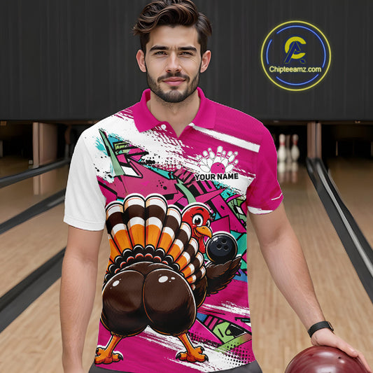 Front view of a male model wearing a pink custom bowling polo shirt featuring a funny graffiti style turkey holding a bowling ball, paint splatter details, and a custom name in a bowling alley.