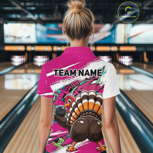 Load image into Gallery viewer, Back view of a female model wearing a pink custom bowling polo shirt with a funny graffiti turkey holding a bowling ball, paint splatter accents, and a personalized name in a bowling alley.