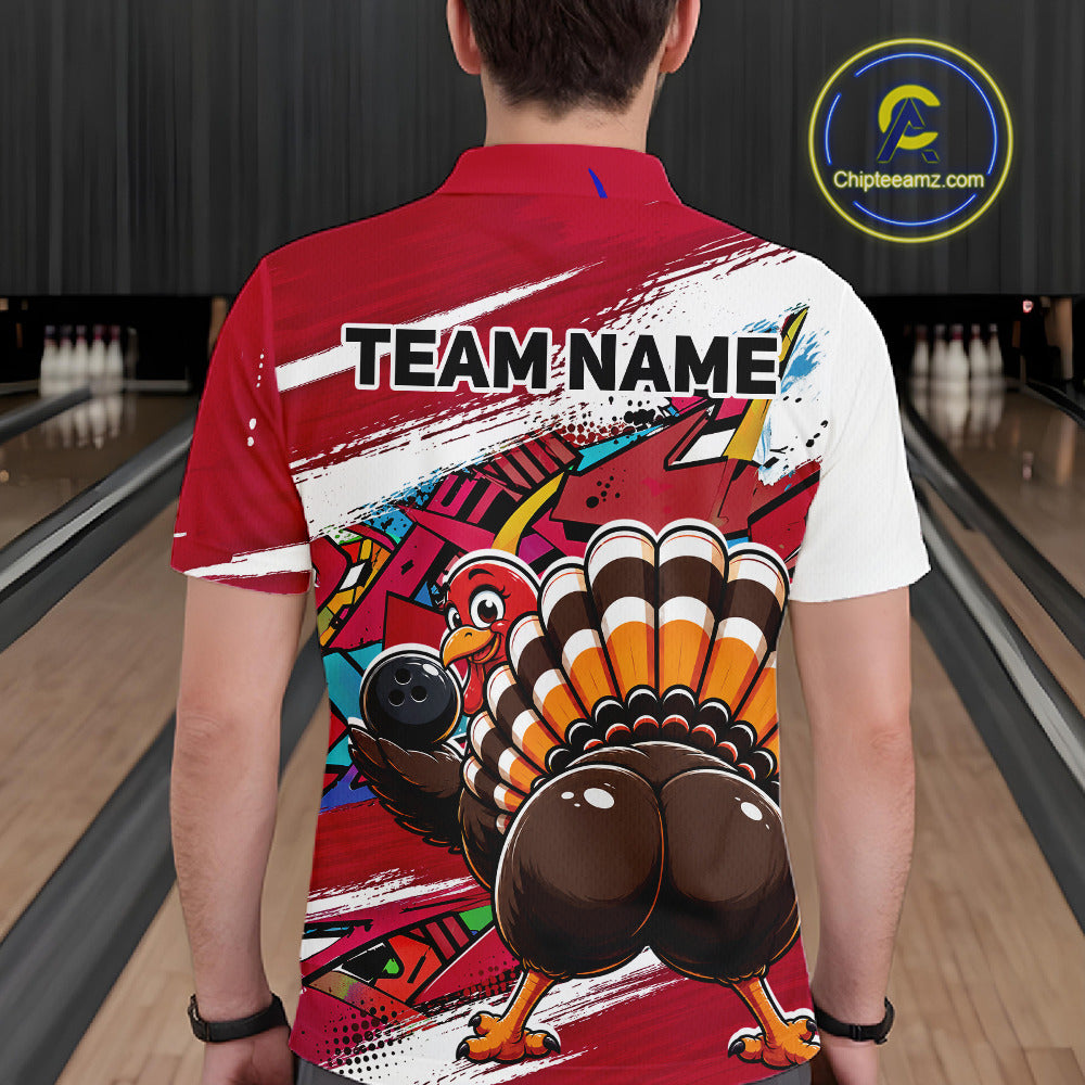 Back view of a male model wearing a red custom bowling polo shirt with a funny graffiti turkey holding a bowling ball, paint splatter accents, and a personalized name in a bowling alley.