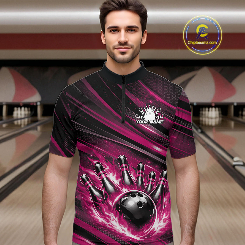 Male model at a bowling lane wearing a black and pink bowling quarter-zip shirt with a fiery bowling strike scene and abstract stripes.