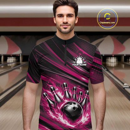 Male model at a bowling lane wearing a black and pink bowling quarter-zip shirt with a fiery bowling strike scene and abstract stripes.
