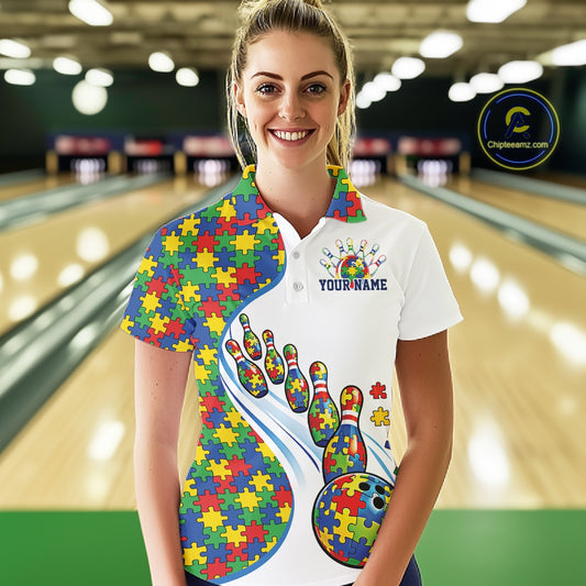Female model in a bowling lane wearing a white polo shirt, front view highlighting autism-themed bowling strike illustration with puzzle-inspired design
