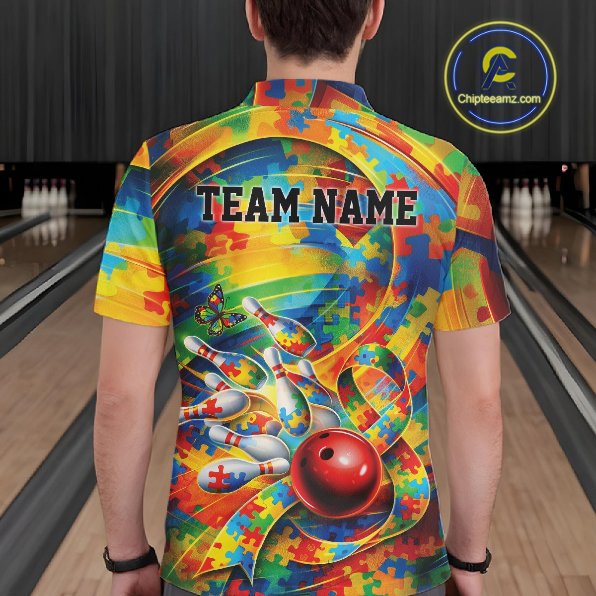 Male model at a bowling lane, back view of colorful polo shirt showcasing autism puzzle bowling ribbon and multicolor design