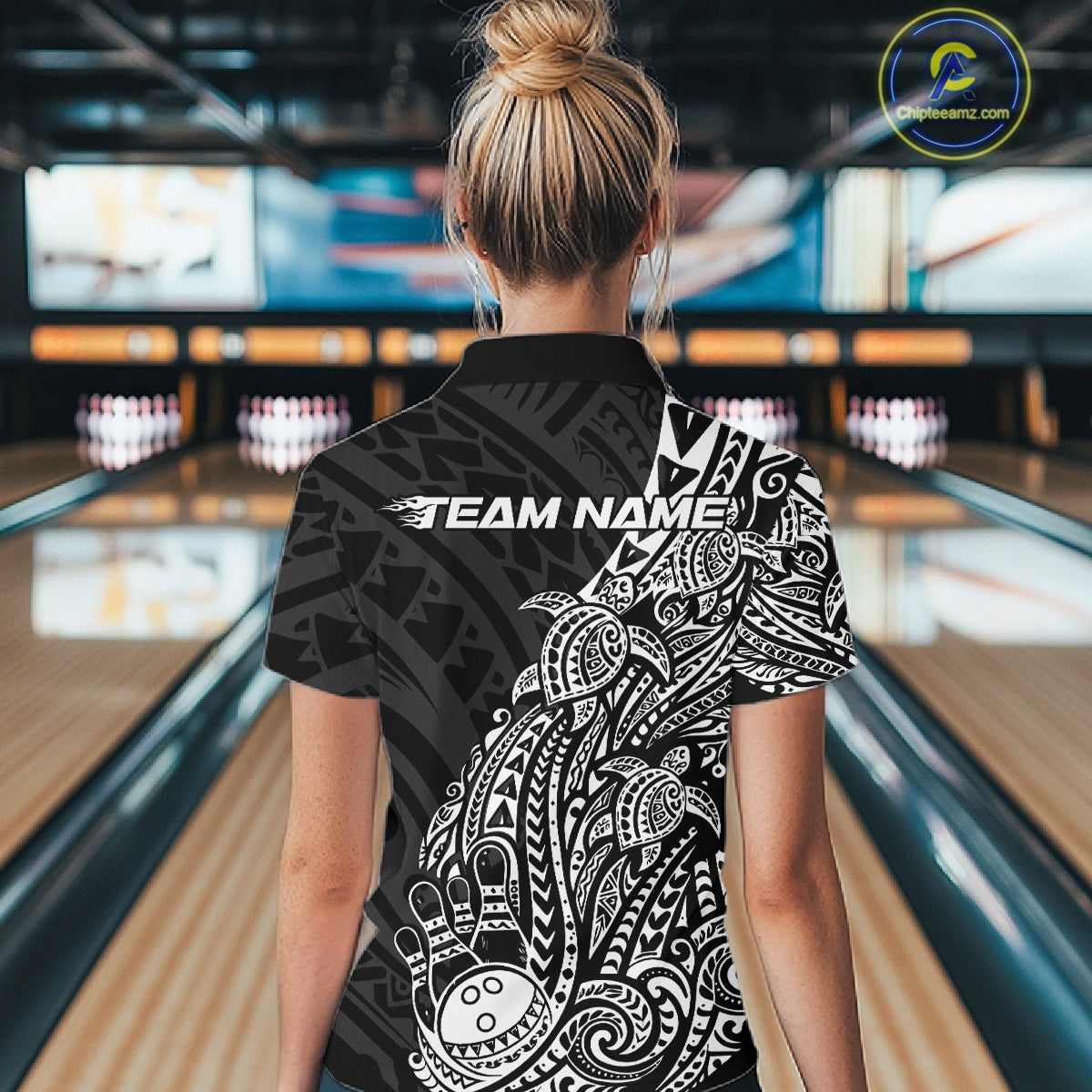 Back view of a female model in a black and white bowling quarter-zip shirt displaying Polynesian-inspired bowling graphics.