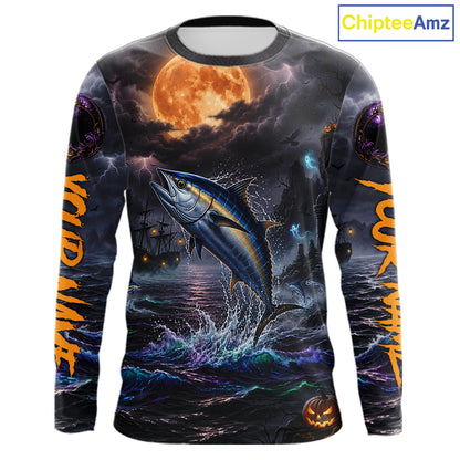 A long-sleeve crewneck shirt with an all-over Halloween-themed graphic print. The design features a large blue tuna fish jumping out of dark, churning water under a glowing orange full moon, with ghostly ships and purple storm clouds in the background.
