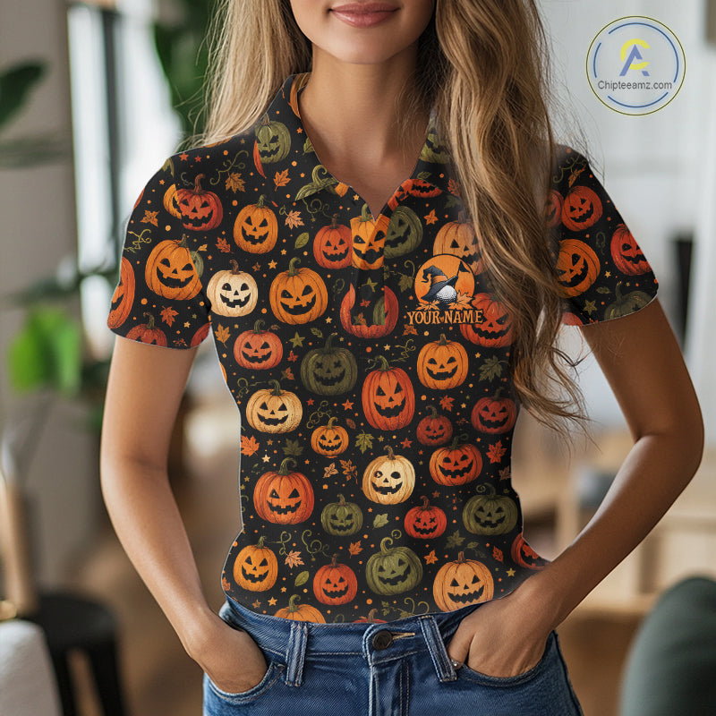 A woman wearing a short-sleeve polo shirt with a Halloween pumpkin print, paired with blue jeans. The shirt features a black background patterned with various orange, green, and yellow jack-o'-lanterns, stars, and a customizable chest graphic.