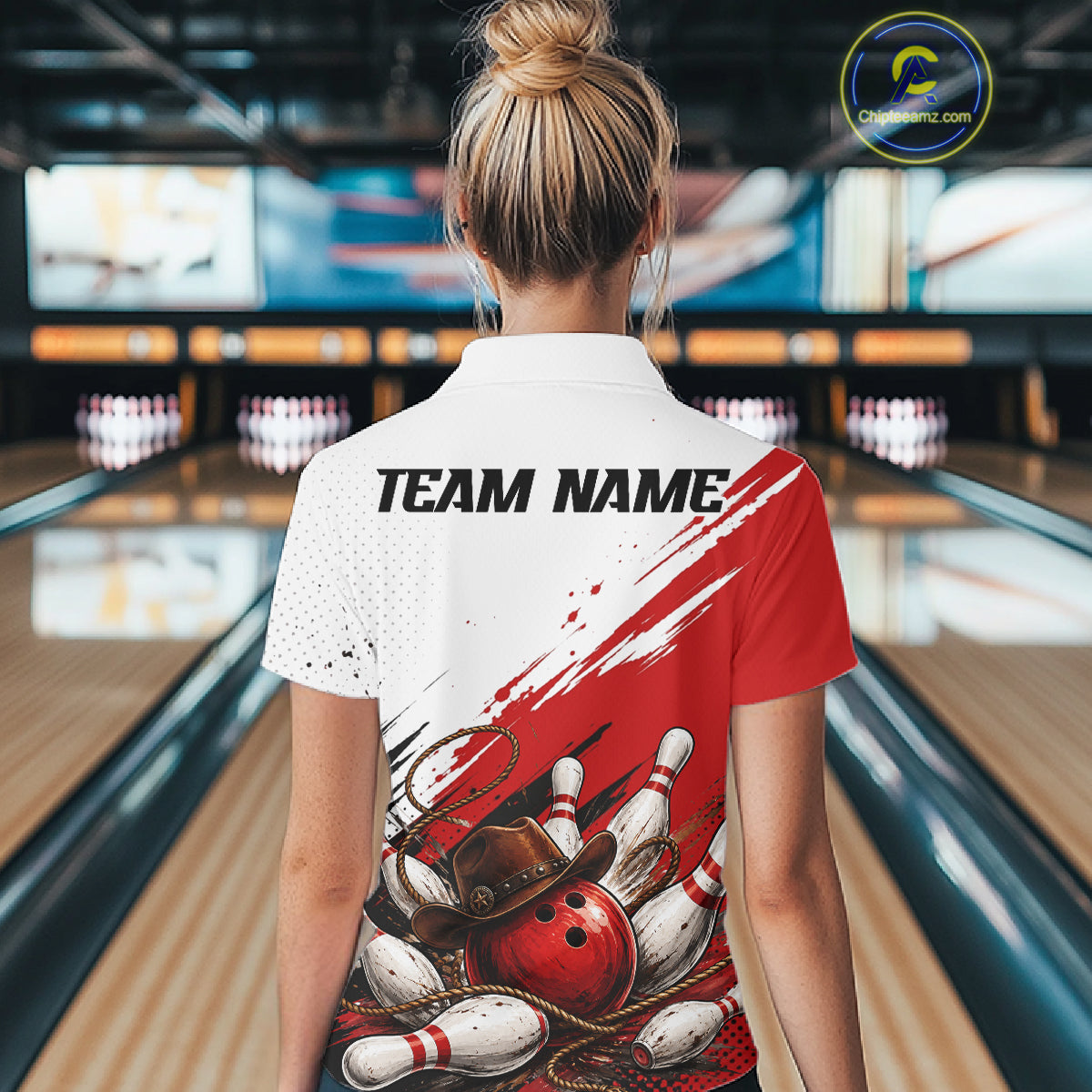 A woman viewed from behind wearing a white and red bowling-themed short-sleeve polo shirt with 'TEAM NAME' printed on the back, standing in a bowling alley.